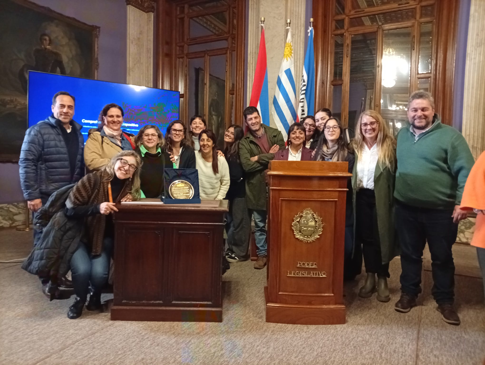 Equipo de Gurises Unidos junto a la placa de reconocimiento en el Palacio Legislativo